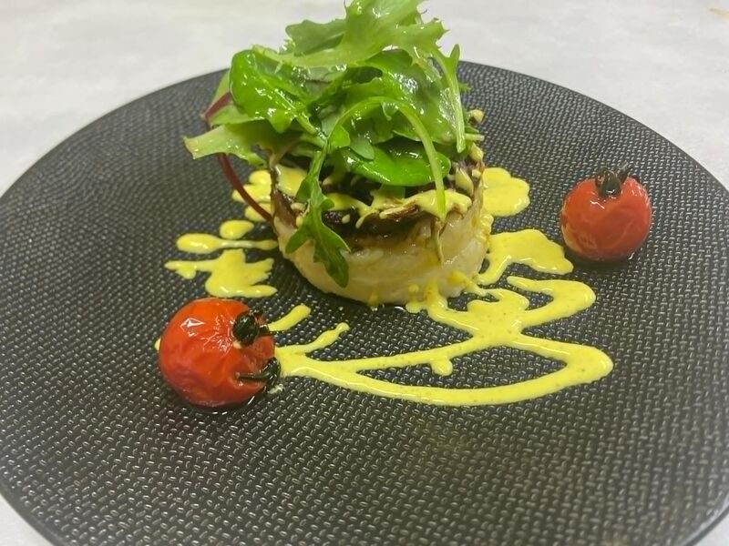 Emincé de confit de canard sur son écrasé de pommes de terre, sa sauce au curry et ses tomates confites