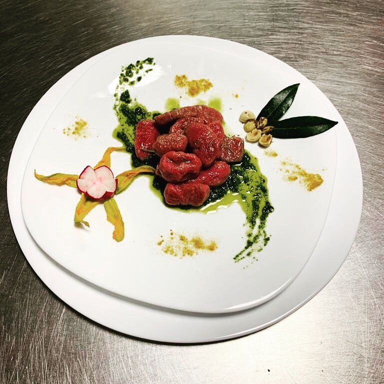 Gnocchi fatti a mano di barbabietole su letto di pesto di rucola e nocciole