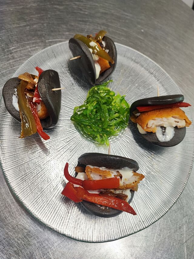 Bao negro relleno verduras y merluza rebozada 