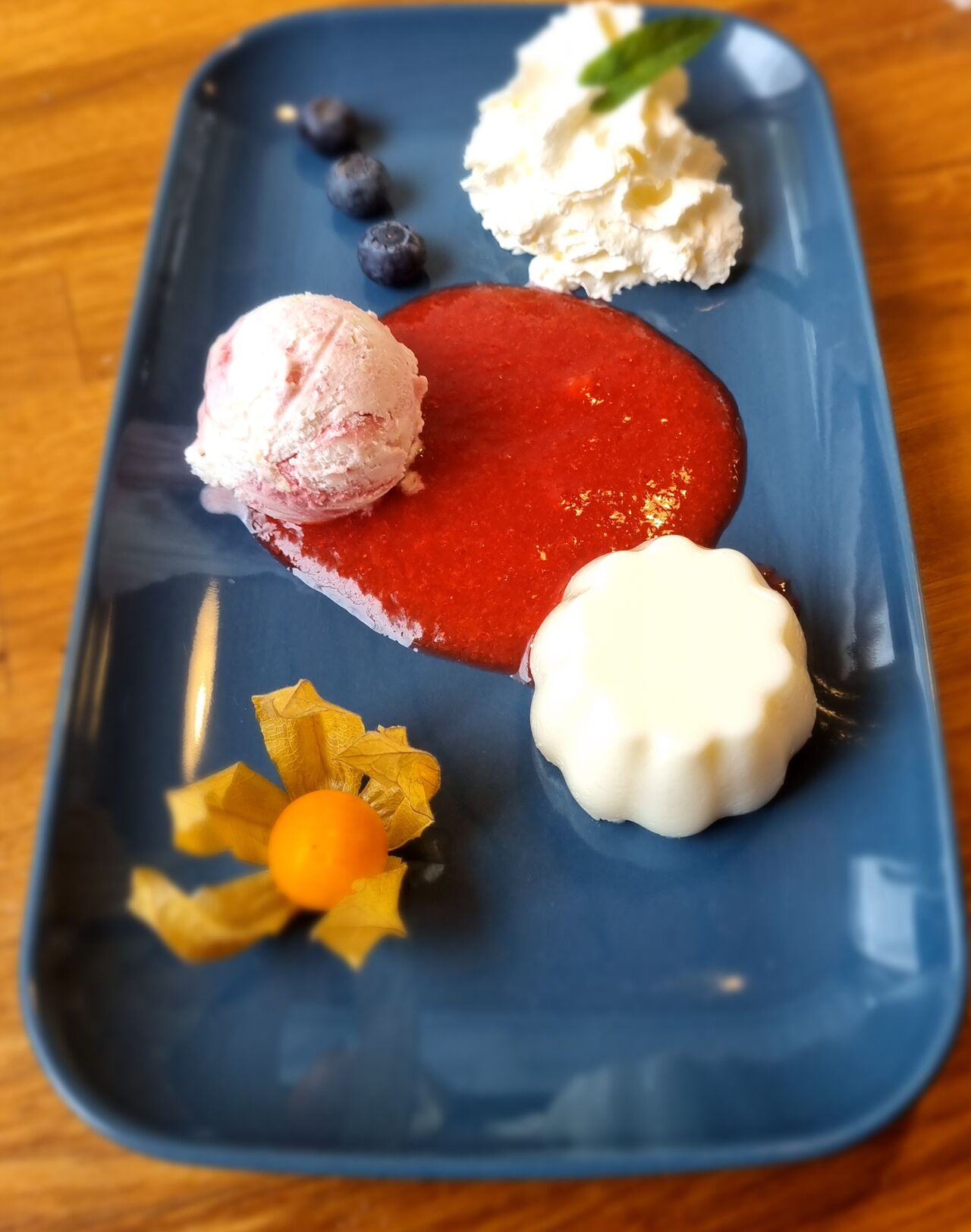 Panna Cotta mit einer Kugel Weißer Schokolade-Himbeere auf Erdbeerragout