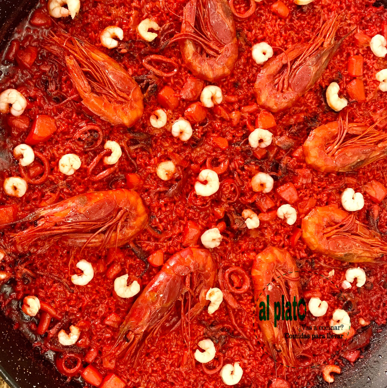 Paella de arroz rojo con carabineros