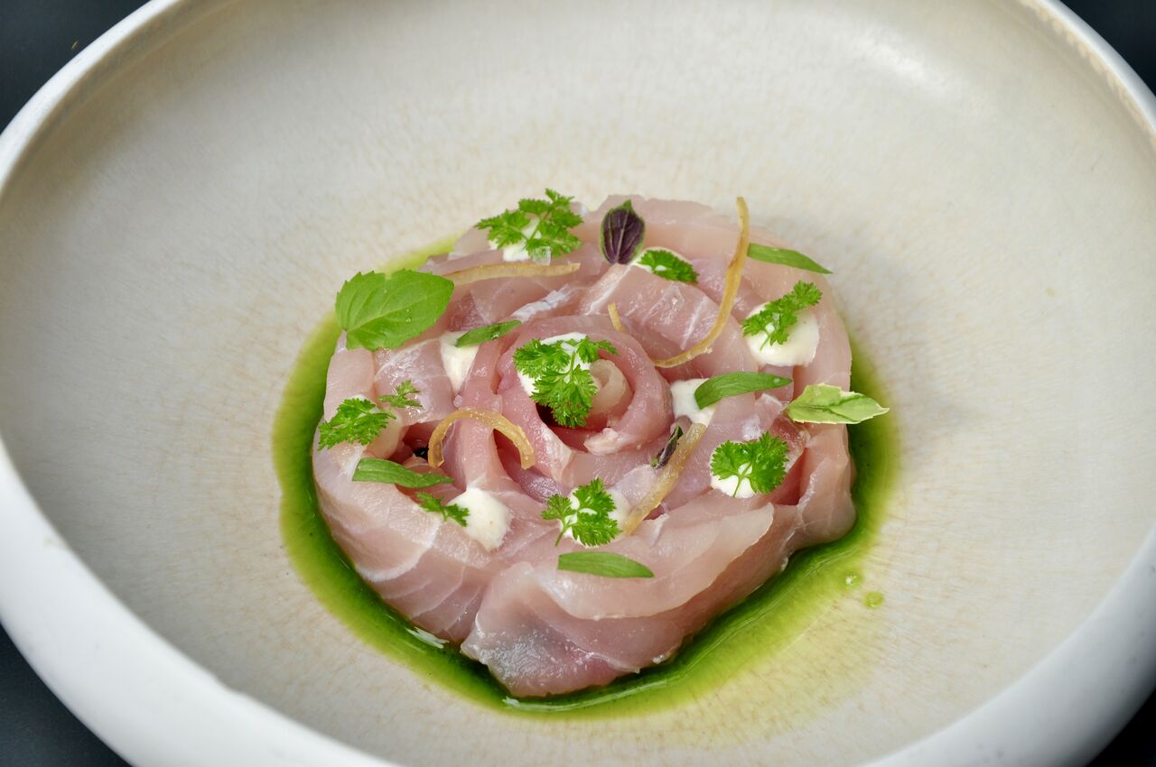 Ricciola marinata, salsa alle mandorle, erbe aromatiche, olio alle foglie di pepe rosa