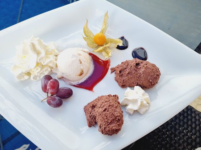 Hausgemachtes Mousse au Chocolate mit einer Kugel Amarena-Kirsch auf Fruchtspiegel