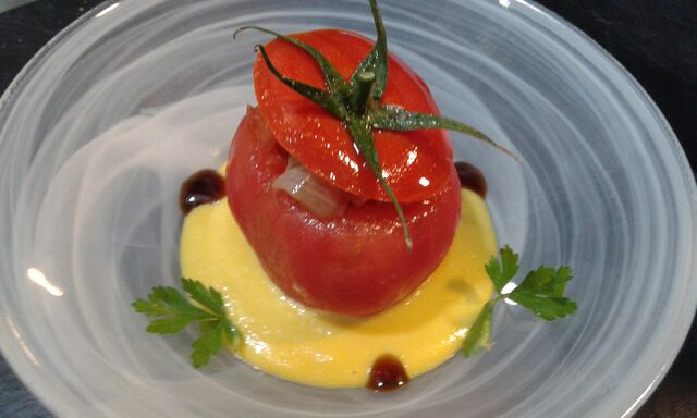 Tomate relleno sobre salmorejo de naranja
