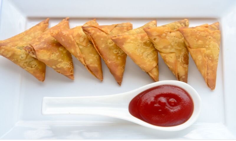 Samosa (Teigtaschen mit Fleisch oder Gemüse gefüllt) mit passenden Dip.