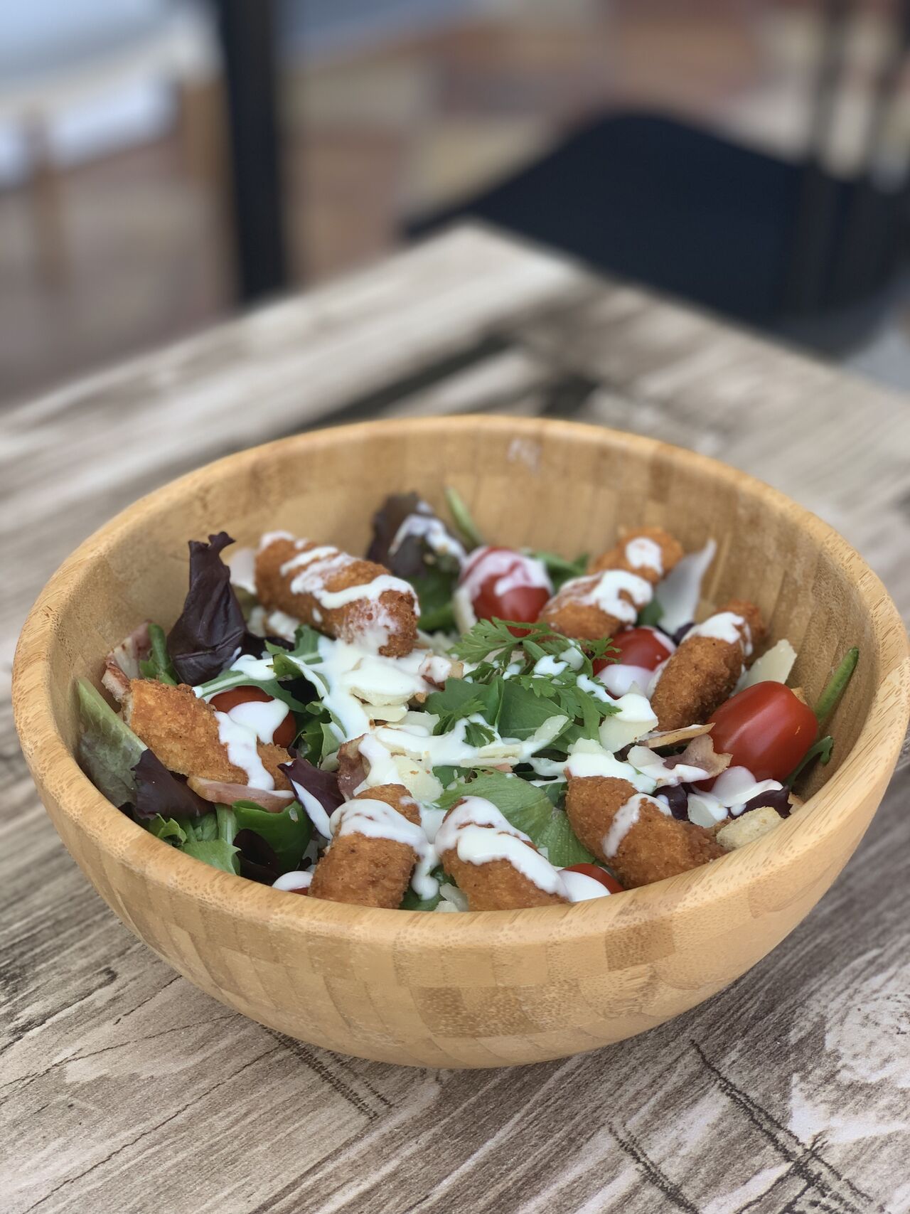 Salade César :
- Filet de poulet pané
- Tomate cerise
- Parmesan
- Croutons
- Oignon rouge