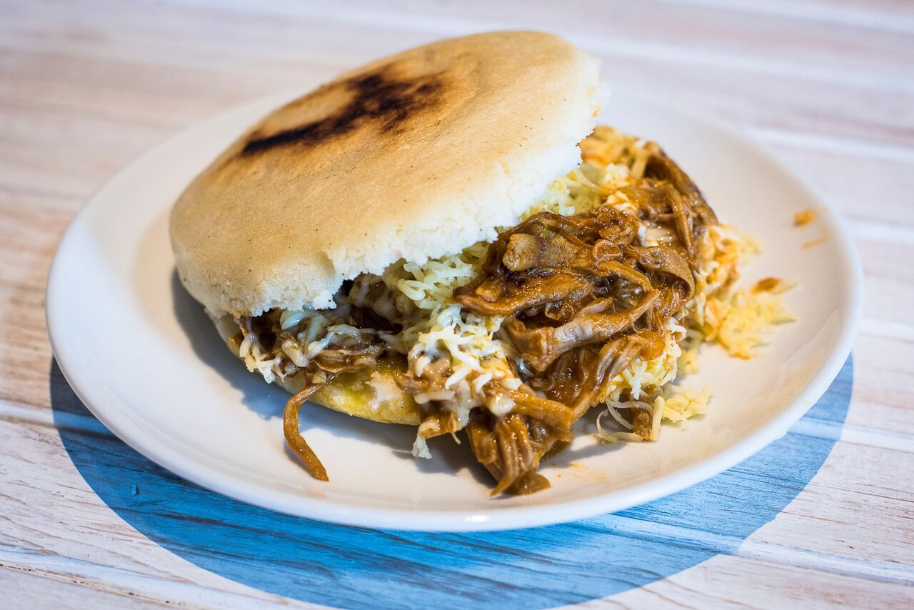 Arepa asada / Masa de maíz cocido de gran tamaño, relleno de carne mechada con queso amarillo