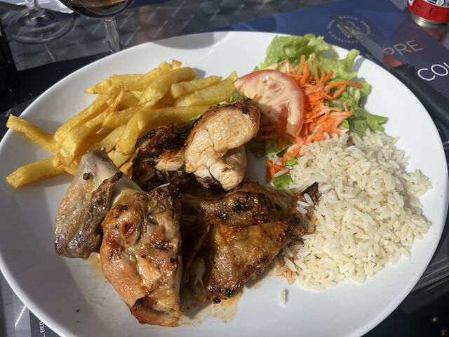  Poulet grillé accompagnée de frites maison, salade verte et riz blanc. 