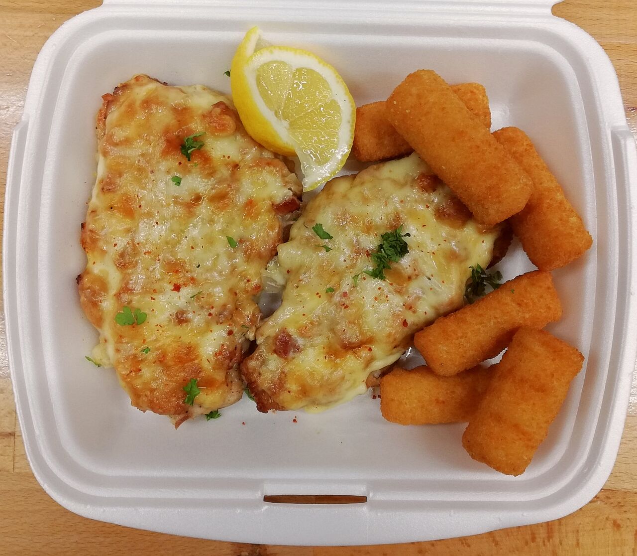 Schweinesteak mit Würzfleisch und Käse überbacken dazu Kartoffelkroketten As
