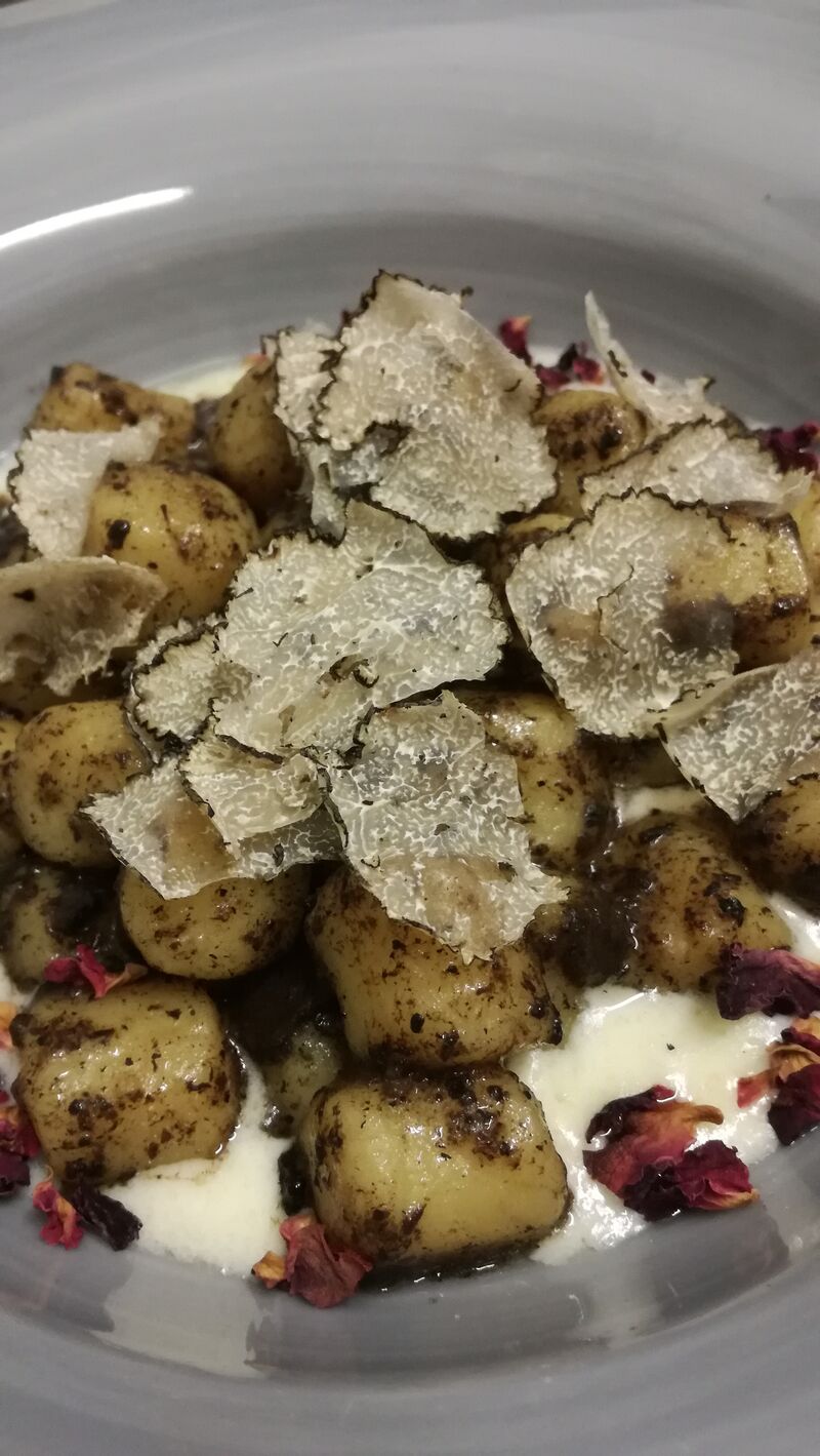 Gnocchi con tartufo serviti su fonduta di taleggio
