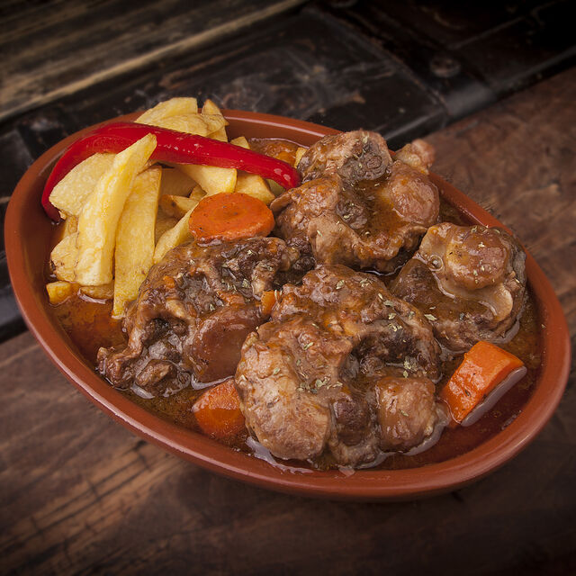 Rabo de Toro en salsa con patatas fritas y pimiento rojo.