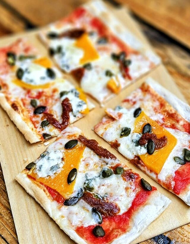 Podpłomyk sezonowy z dynią, serem blue, suszonym pomidorem.