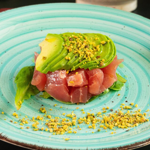 Tartare di tonno con un letto di misticanza e ricoperta di avocado.