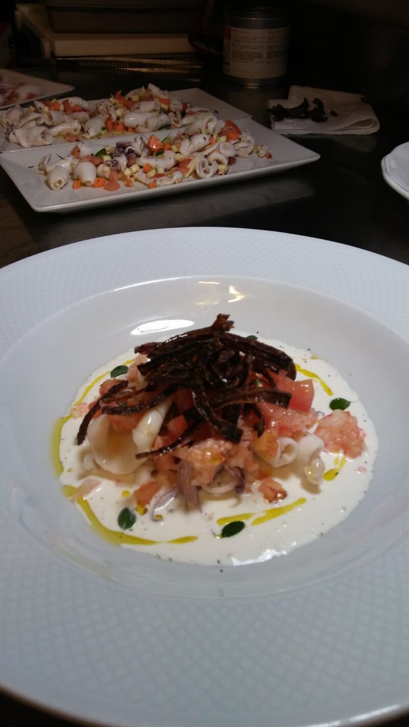 Tartare di gambero rosso di Mazara con calamaretti al vapore pomodorini timo e maggiorana cipolla croccante su crema di burrata