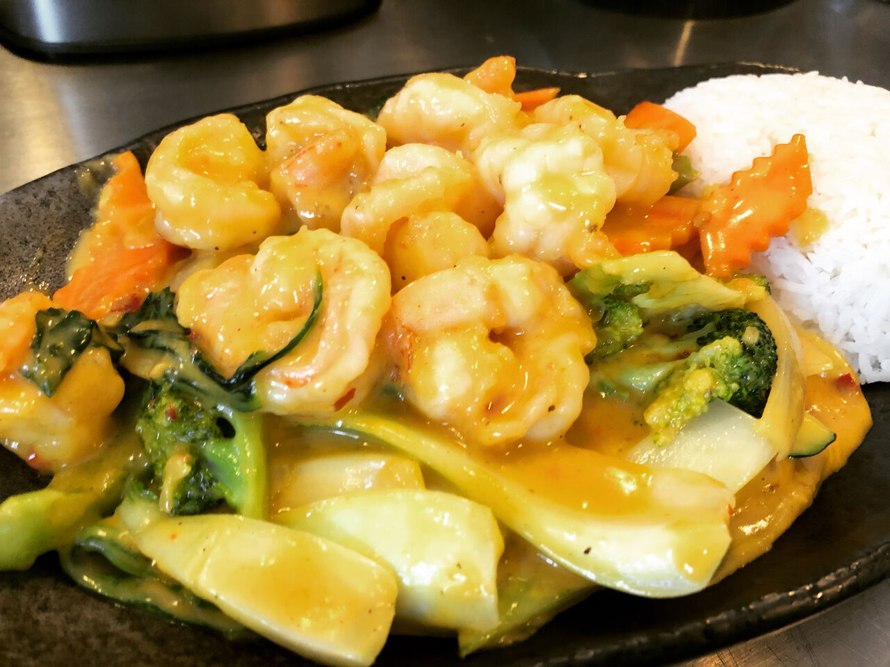 Garnelen auf Mango-Curry Soße mit Reis und Gemüse