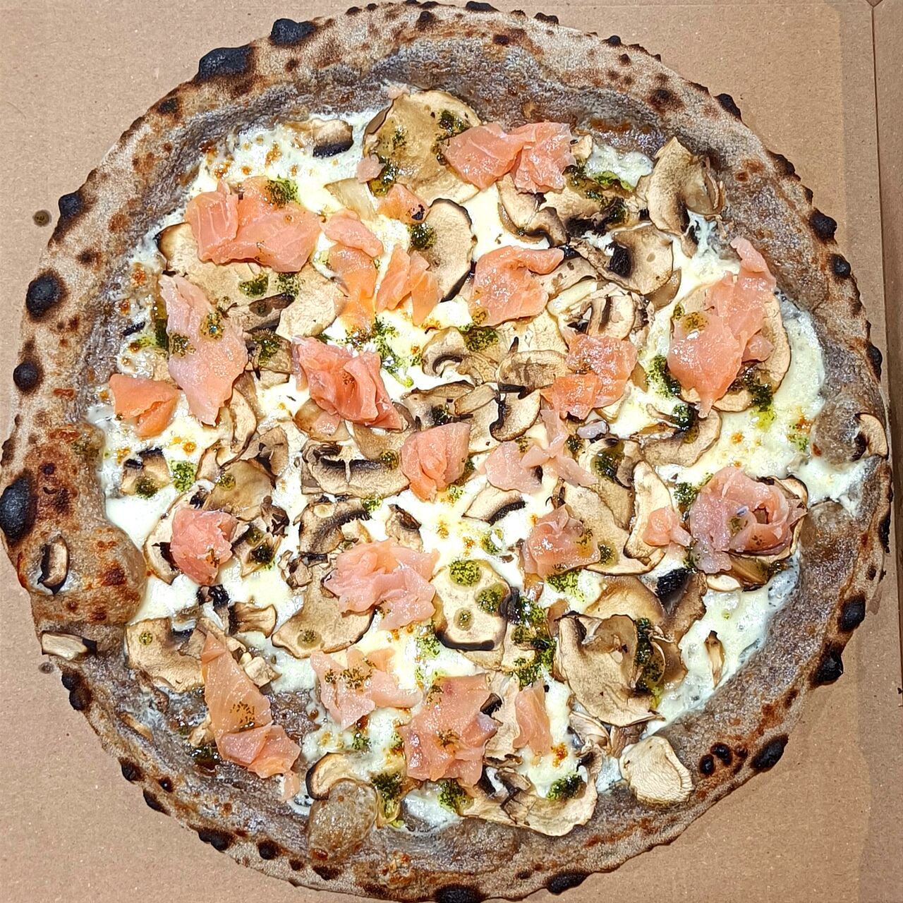 Pizza Salmone - Base crème, mozza FDL, champignons, après cuisson: saumon fumé et sauce aneth maison 