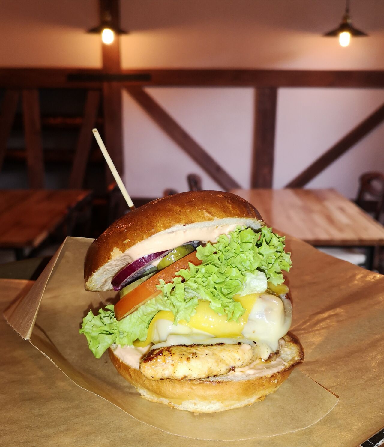 Country chiken burger ( grillowana pierś z kurczaka,bekon,cebulka czerwona,ogórek marynowany, pomidor,sałata,ser gouda,sosBBQ) 