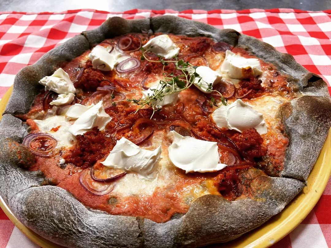 Pizza Nduja na cieście z aktywnym węglem z pikantną kiełbasą Nduja, mascarpone i czerwoną cebulką