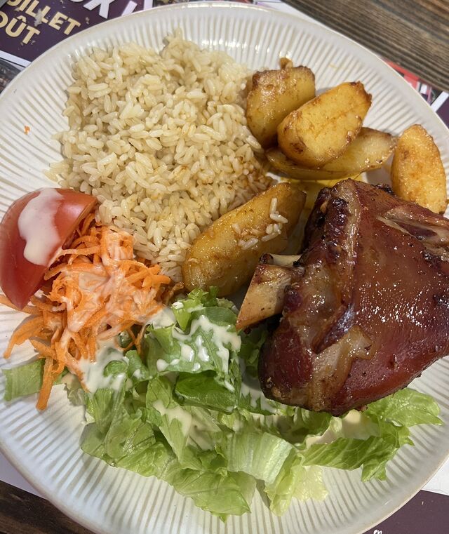  Jarret de porc accompagné de pomme de terre maison, salade verte et riz blanc.