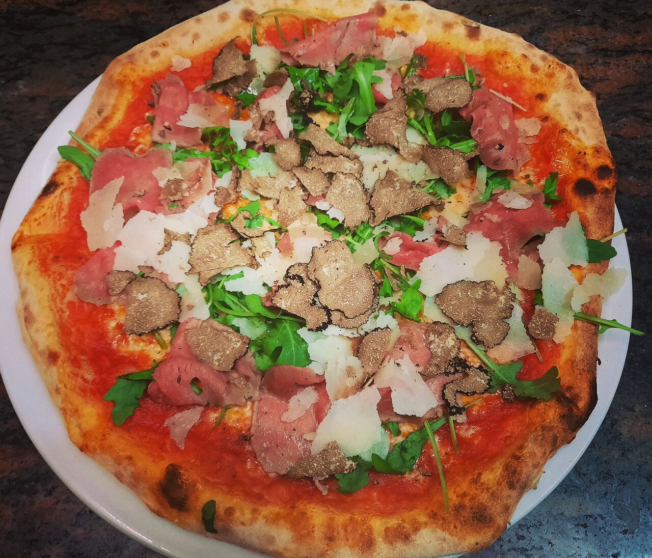 Pizza Tartufo mit Rindercarpaccio, Trüffel, Rucola und Parmesan 