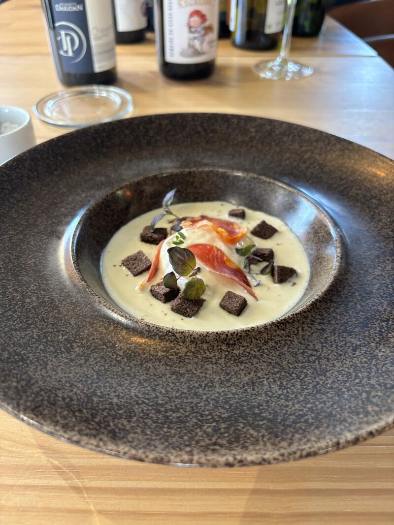 Oeuf poché, crème d'époisseur ,croûtons de pain noir et chips de lomo de porc 