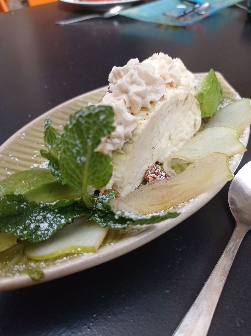 Dessert glacé, fond en dattes, noix de pécan, coco, mousse d'avocat, mangue et chantilly pralinée