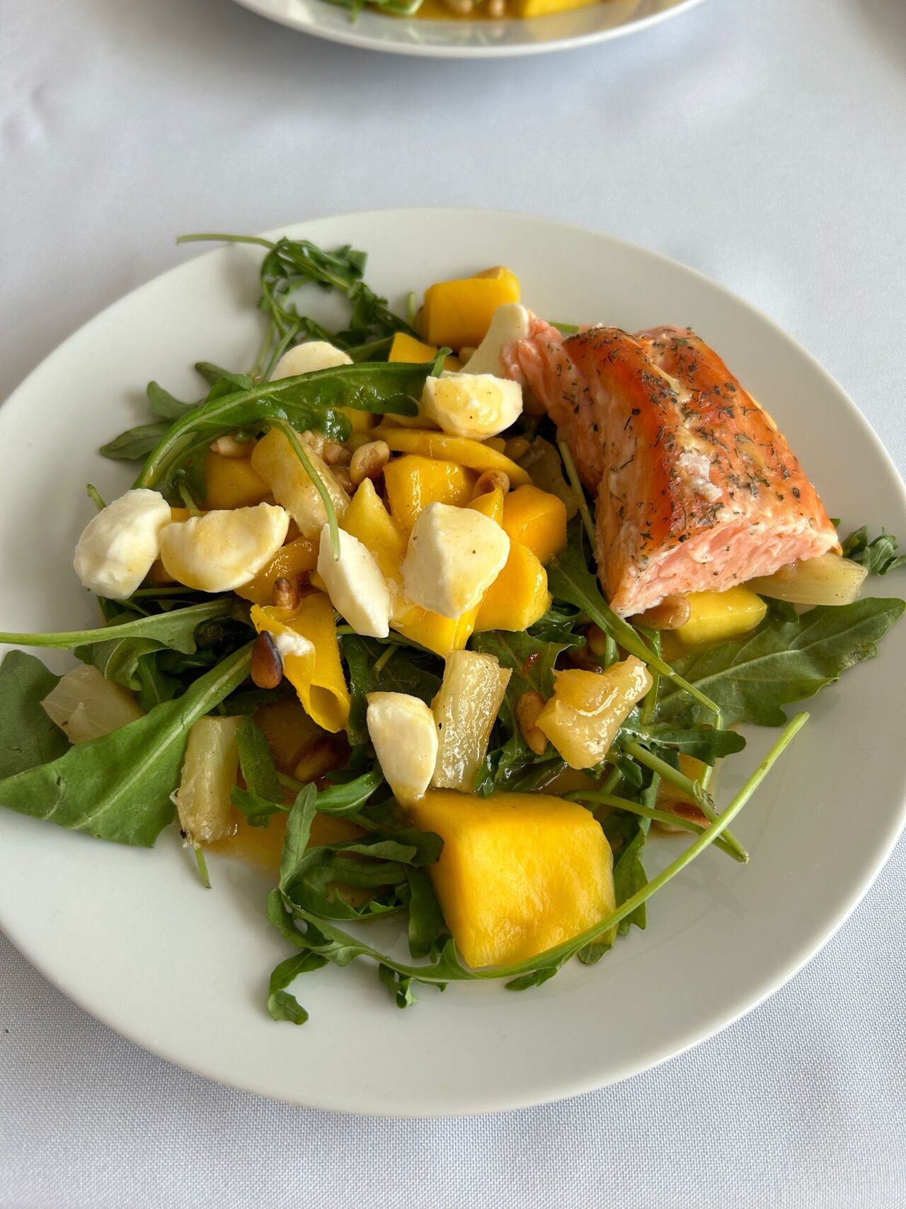 Rucola mit Mango Mozzarella gesmokter Lachs mit Orangendressing