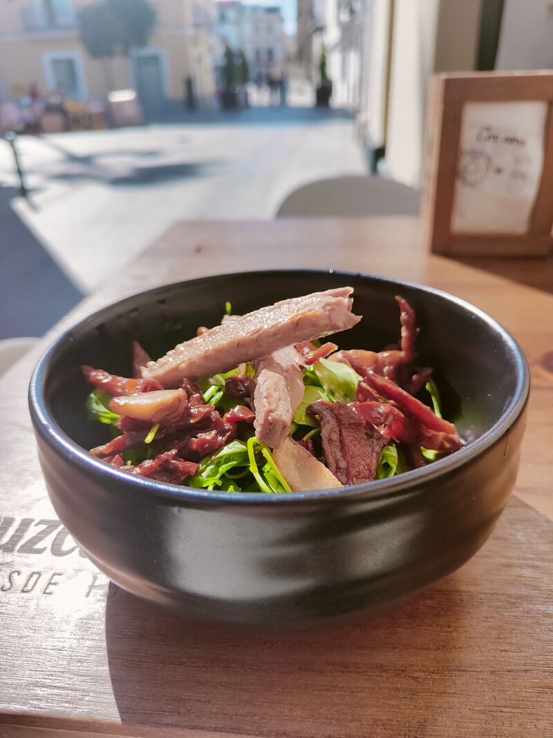 Ensalada de rúcula, tomate deshidratado, ajos confitados y melva canutera