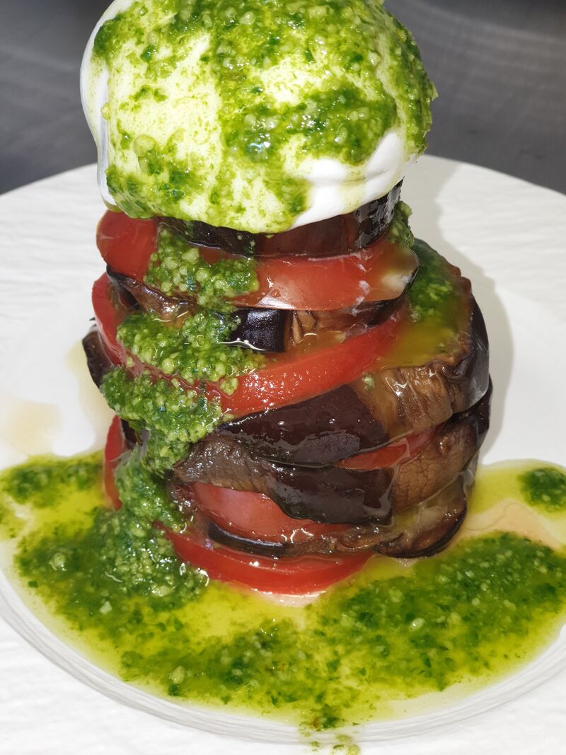 Millefeuille de tomates, aubergines et burrata au pesto.