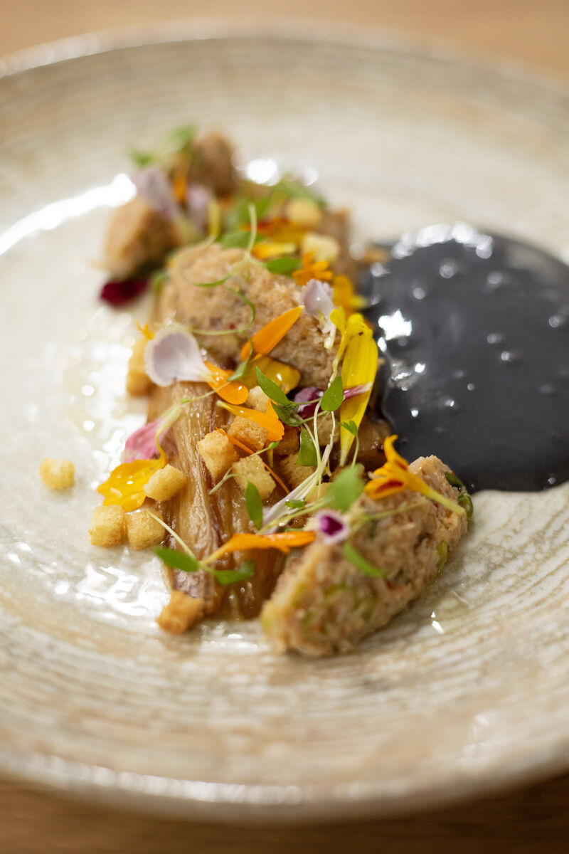 Endive braisée orange/soja, chaire de tourteau, hollandaise au charbon végétal, croutons et fleurs de soucis