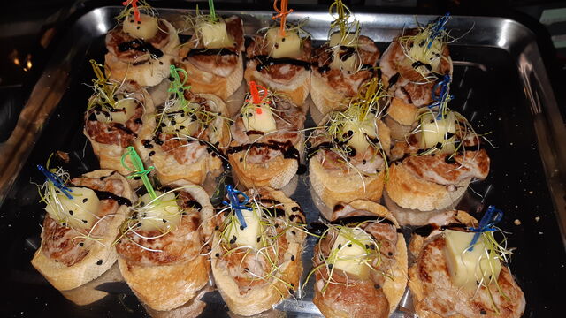 Pintxo de solomillo y cheddar con brotes de cebolla.