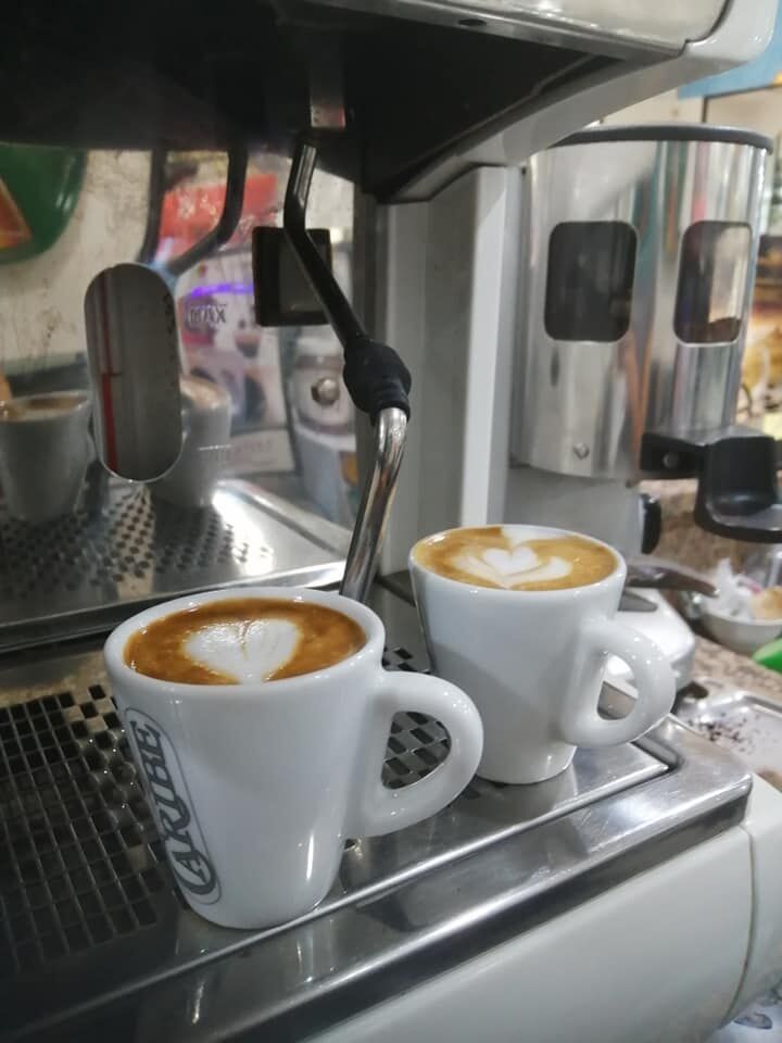 panino condito con pomodoro, mozzarella e insalata,due caffè macchiati