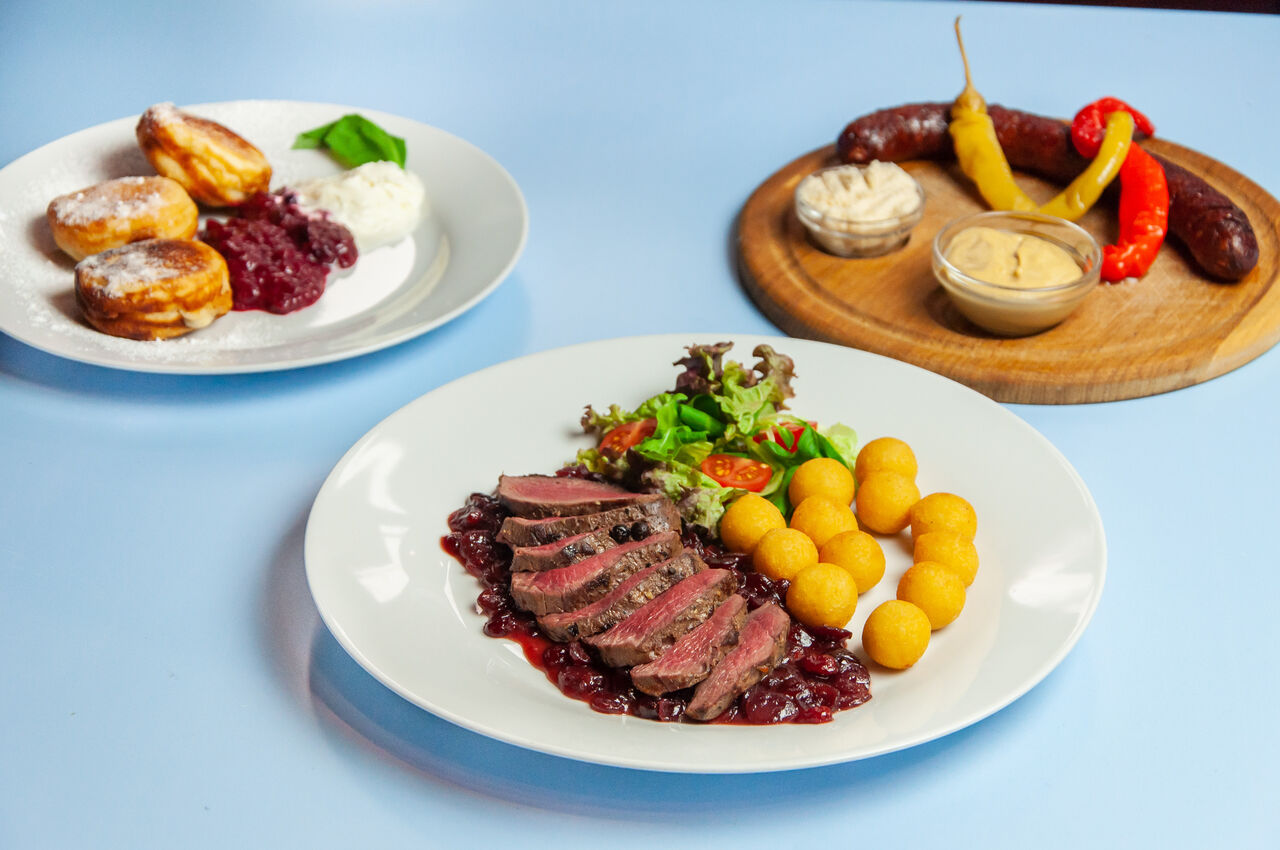 Dančí medajlonky na brusinkách, zvěřinová klobása a lívance s lesním ovocem