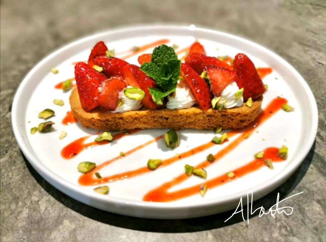 Tartelette fraise chantilly sur un palet breton au piment d'Espelette, coulis de fraise et brisure de pistache.