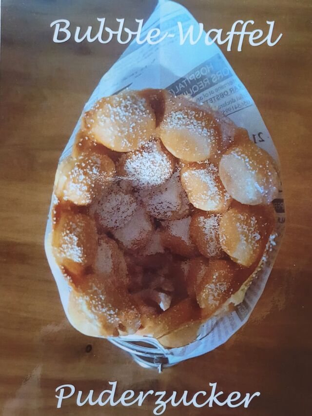 Unsere warme Bubble-Waffel mit Puderzucker schmeckt groß und klein.