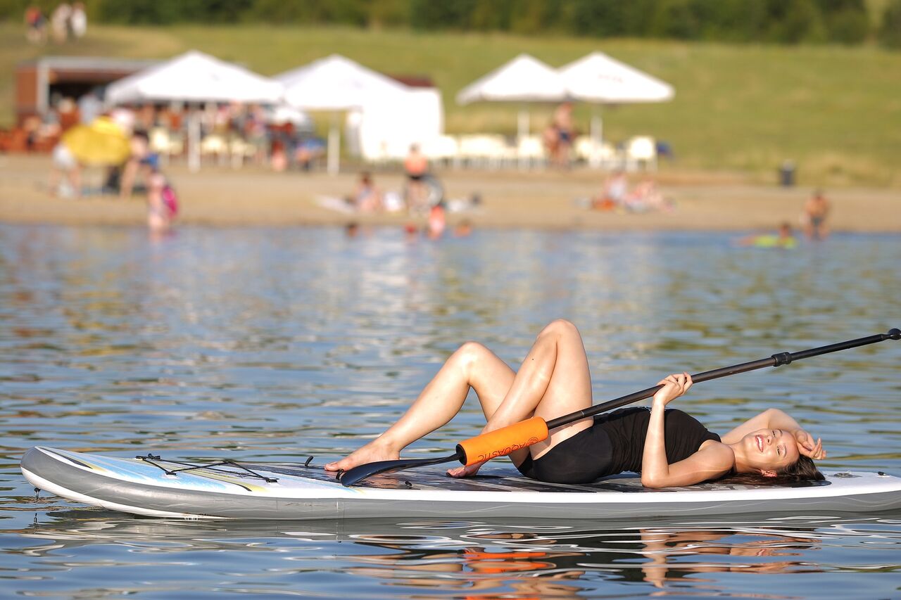 Modelka Verča s naším paddleboardem na jezeru Milada