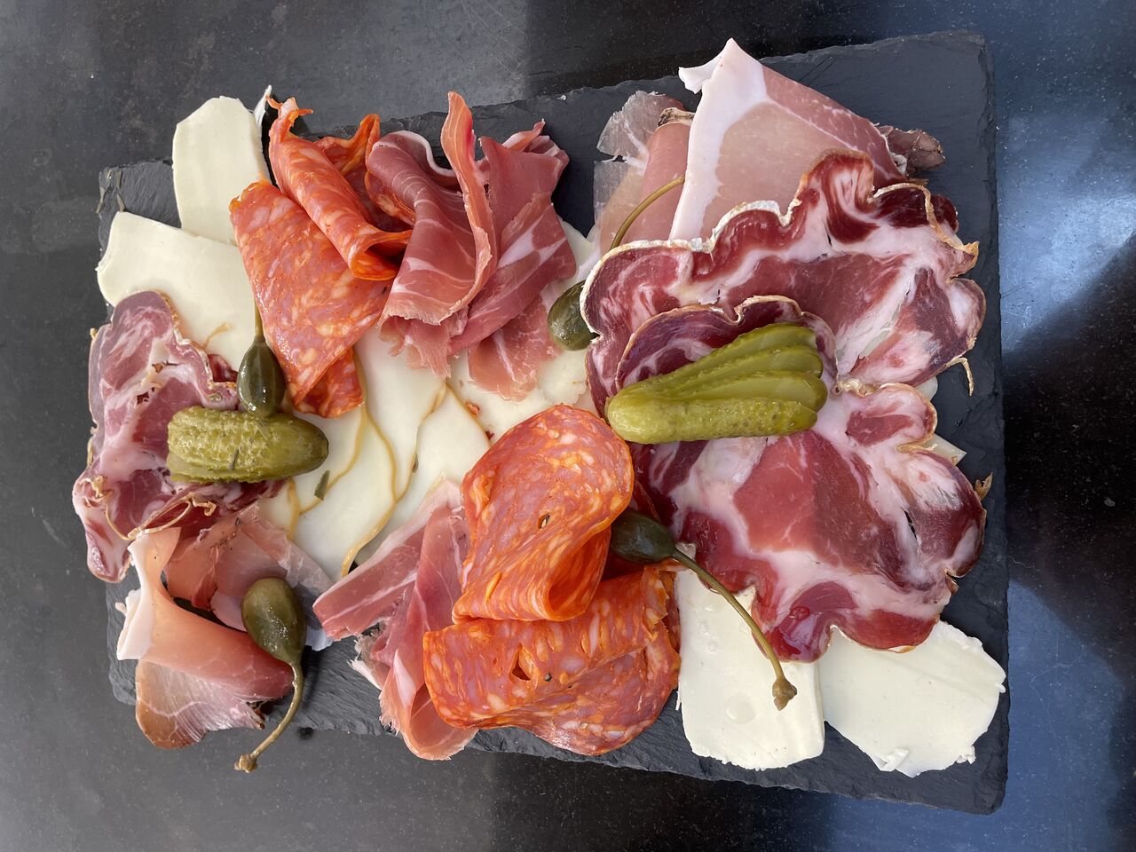 Planche apéritive à partager, charcuteries et fromages italiens.