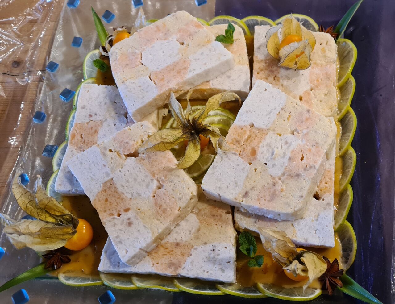 Terrine de Langoustines au lait de coco et citron vert, saumon et tacaud aux kaki, posé sur une gelée de langoustine. 