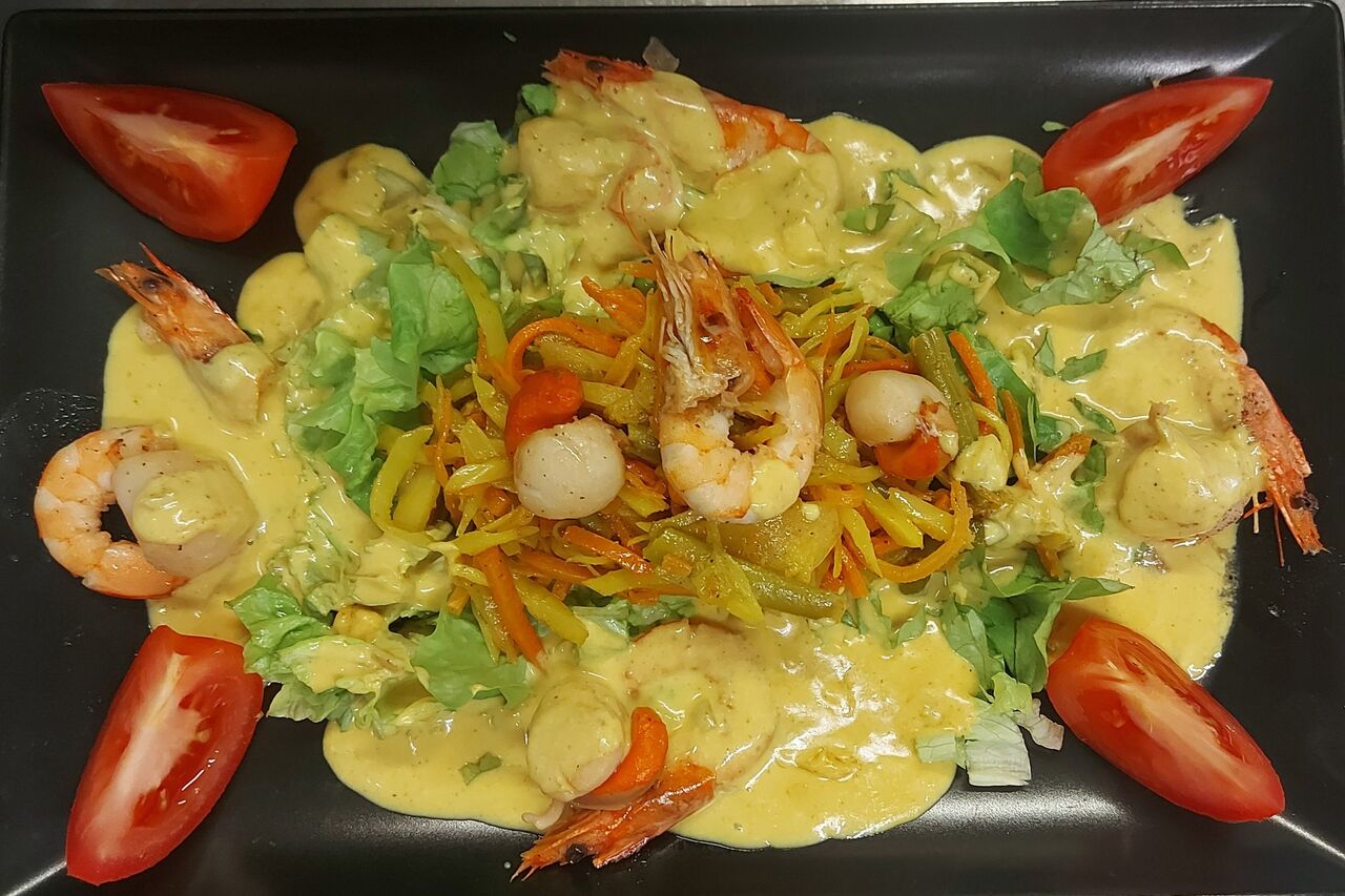 Flambée de noix de saint Jacques et crevettes, sauce coco curry au rhum.