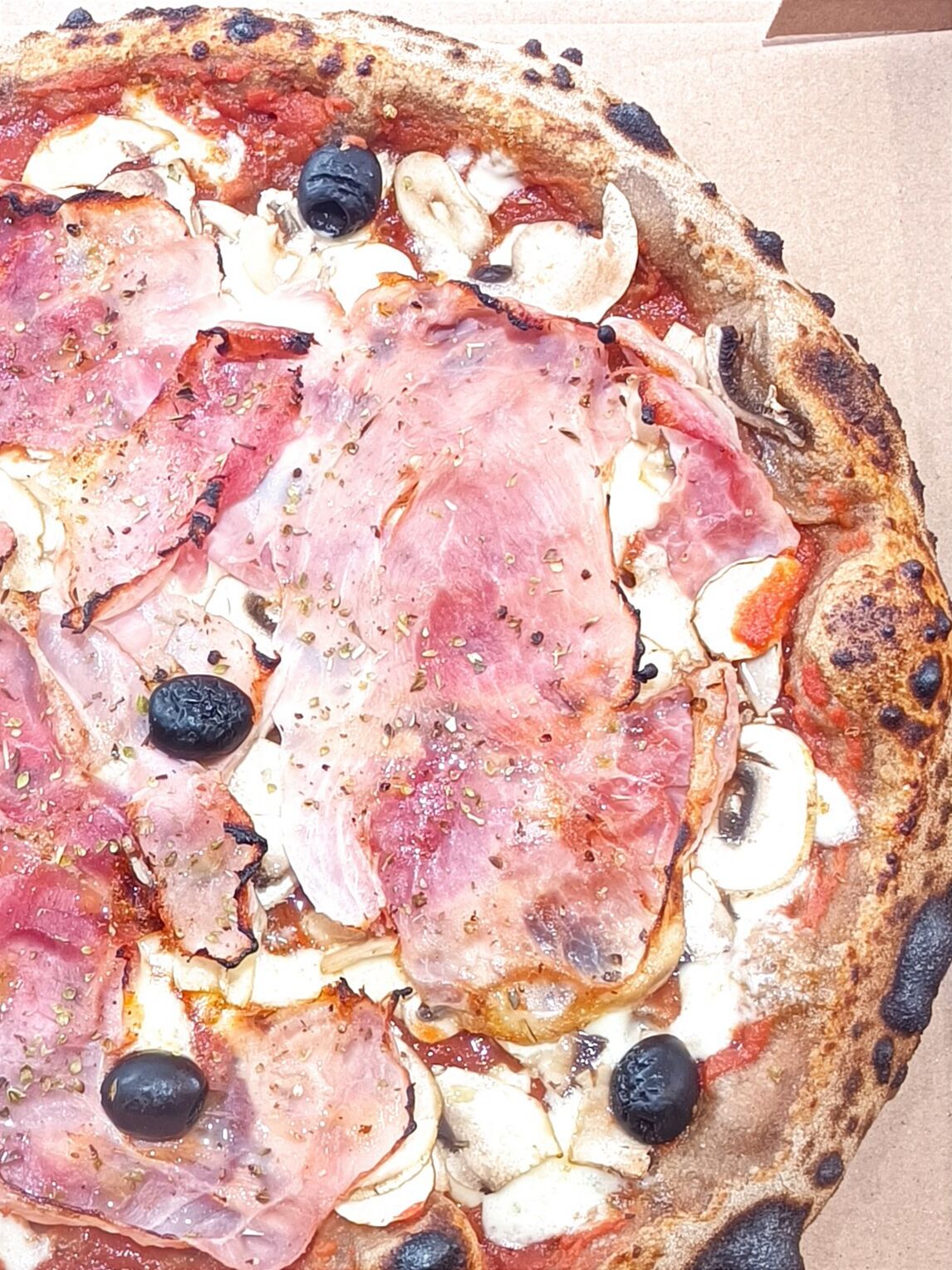 Pizza Regina - Base tomate, mozza FDL, champignons, jambon blanc, origan, olives noires, filet huile olive