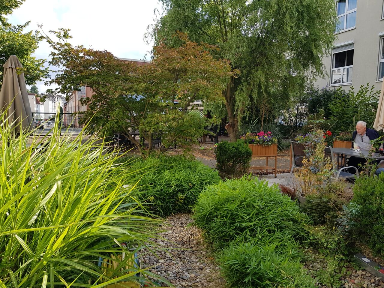 Der Garten beinhaltet viele Sitzgelegenheiten mitten im Grünen, mit viel Schatten.