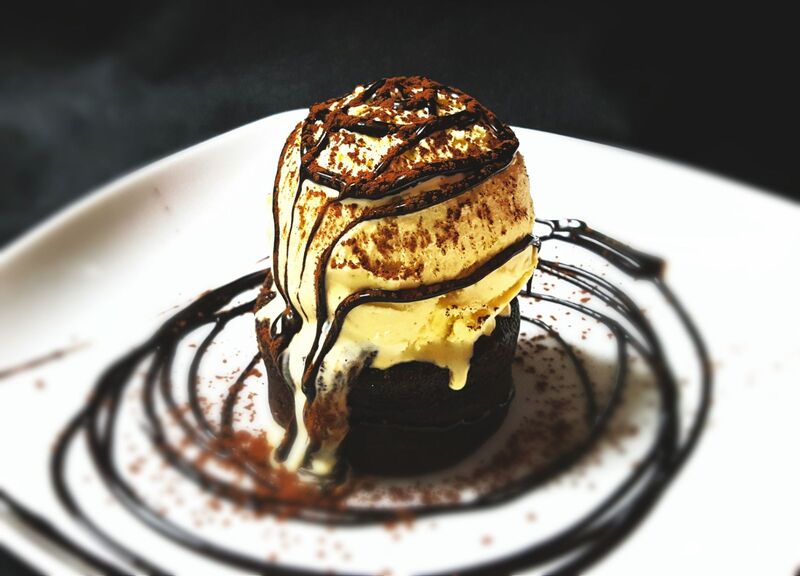 Esponjoso Coulant de chocolate calentito, chocolate extra negro y helado de vainilla bourbón