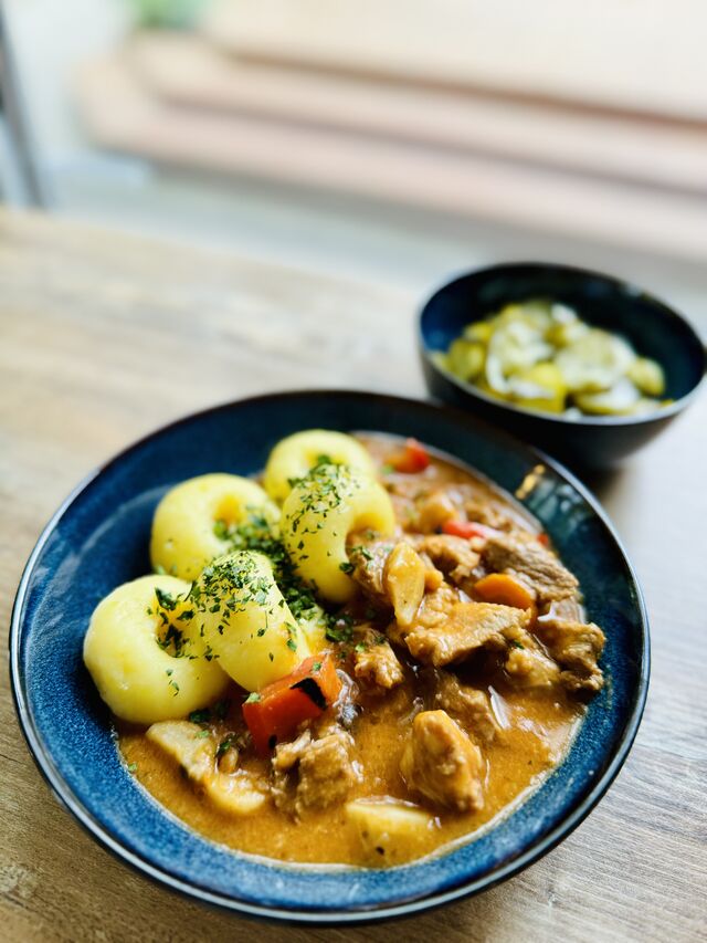 Gulasz wieprzowy z kluskami śląskimi i sałatką z ogórka kiszonego