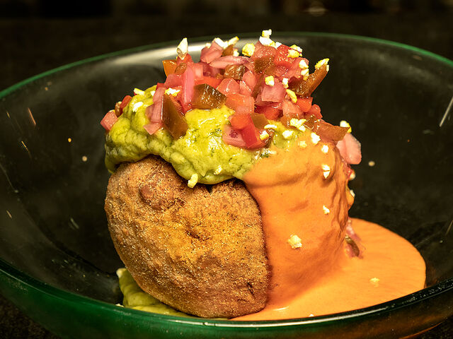 Bolón de plátano macho relleno de chicharrón y queso, acompañado de guacamole, salsa de habanero y ají Esmeraldas