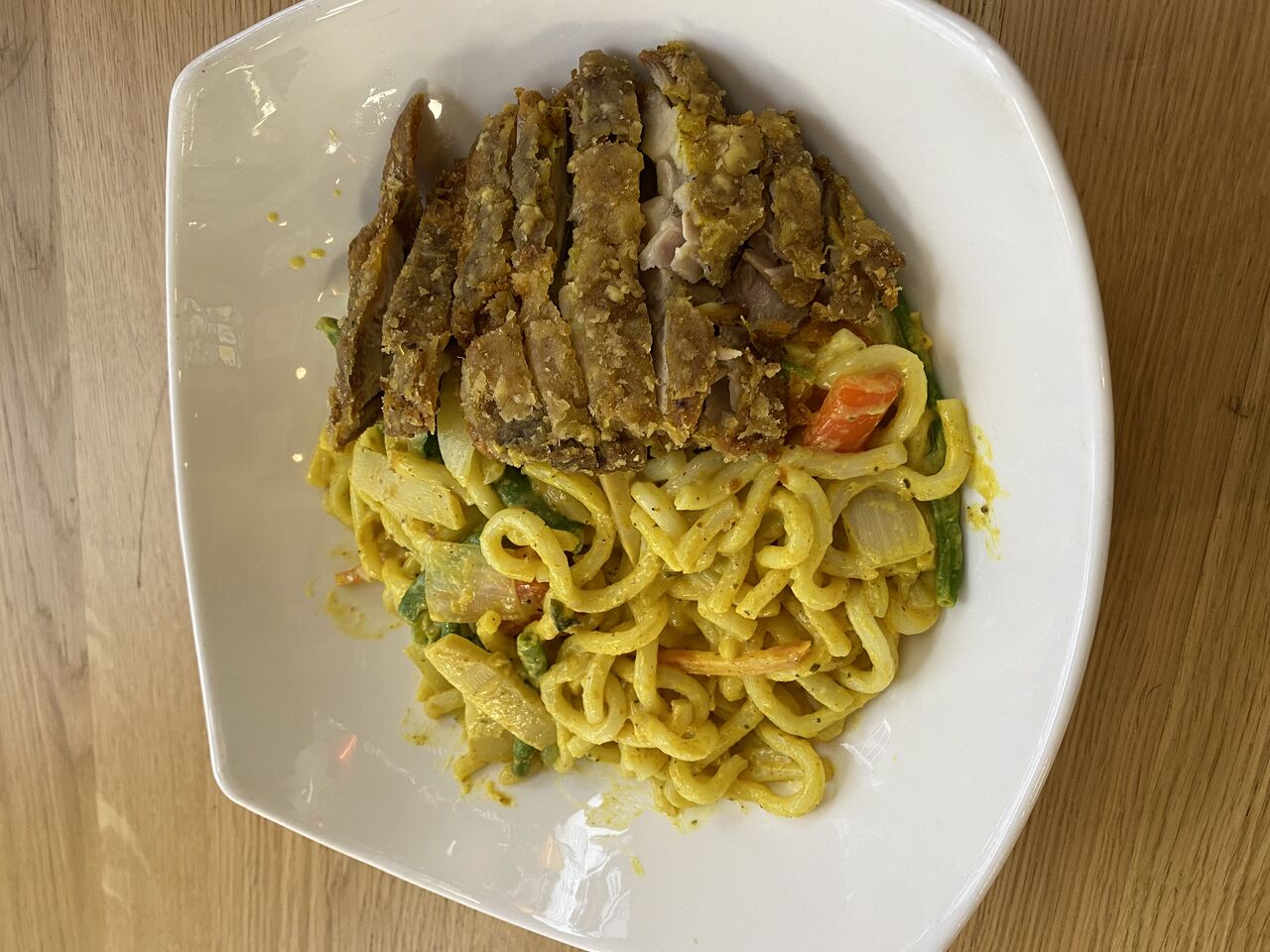 Udonnudeln im Erdnuss-Mango Soße mit knusprig Hähnchen Schenken