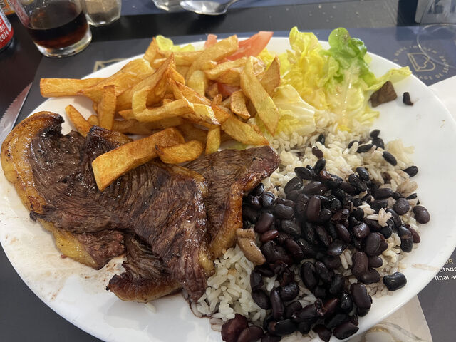 Picanha accompagnée de frites maison, salade verte, riz blanc et haricots noirs.