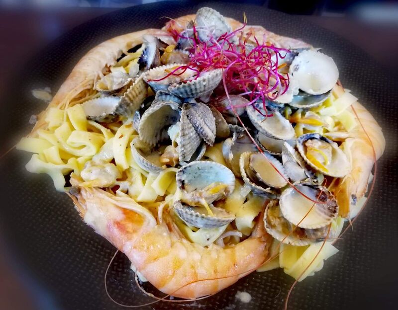 Coques et crevettes au curry vert sur nid de pâtes fraîches 