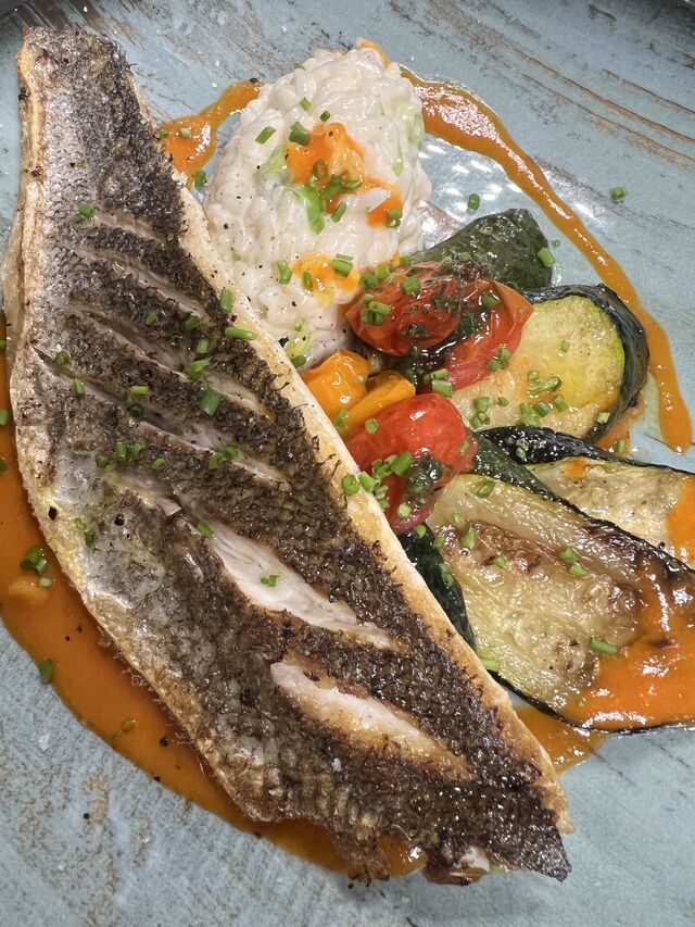 Le Filet de Bar à la Plancha, Sauce Poivrons Rouges au Piment d’Espelette et Légumes de Saison sur le Fameux Risotto du Chef