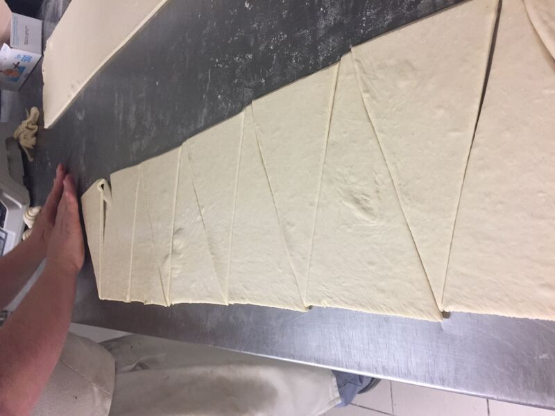 Le pâtissier en pleine préparation pour réaliser des croissants au beurre 