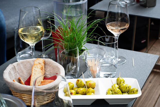 Unter anderem bieten wir selbst eingelegte Oliven in verschiedenen Varianten an, die hervorragend zum Wein passen.